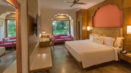 Premium Room with double bed, tv, sofa and desk at Heritage Village Resorts & Spa, Manesar.