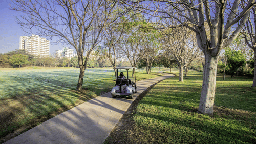 a golf buggy being driven on a pathway on the golf course at Karma Lakelands.