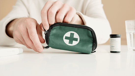 Open first aid pouch with medical supplies arranged on a table.