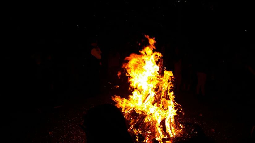 A bonfire burns brightly against the night sky, celebrating the Hindu festival of Holika Dahan. 