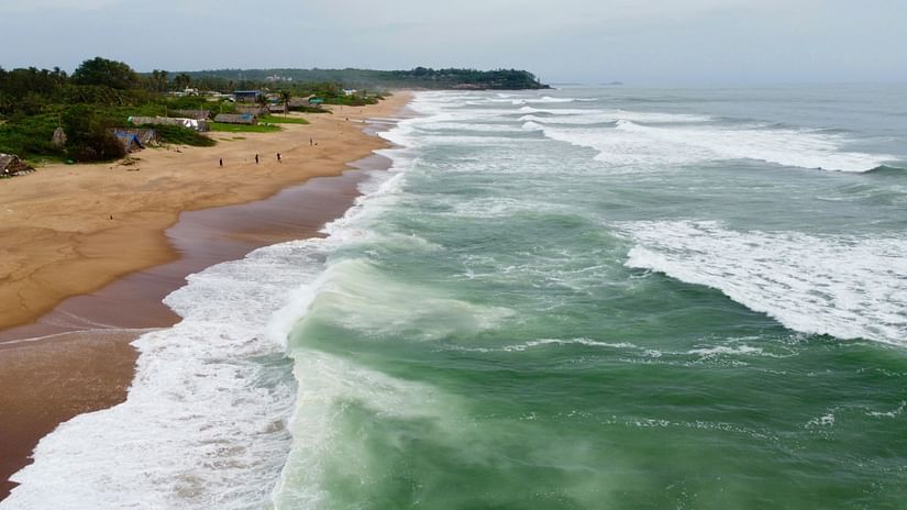 A calm stretch of Candolim beach with waves rolling in.