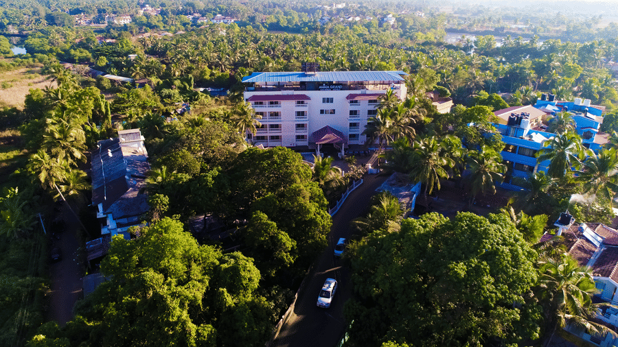 Aerial view of Amara Grand Baga, Goa, with buildings and trees surrounding it.