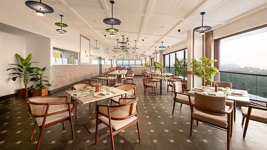 Elegant dining space with tables and chairs, featuring fancy lights hanging from the ceiling at Cloud9 Sarovar Premiere, Palolem Goa.