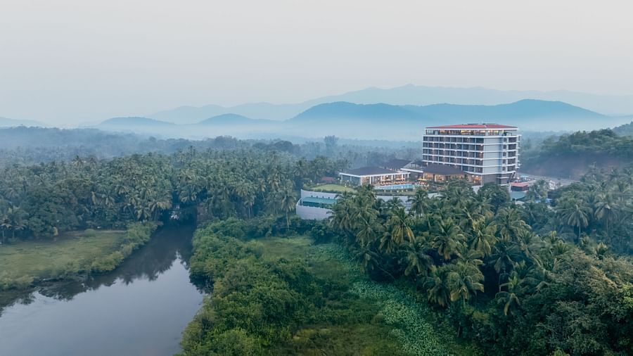 an image of aerial view of Cloud9 Sarovar Premiere, Palolem Goa surrounded by trees and mountains and water body