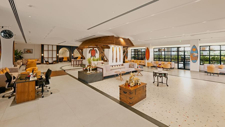 Lobby space featuring sofas and chairs, with a wall hanging turtle craft and decorative paddles at Cloud9 Sarovar Premiere, Palolem Goa