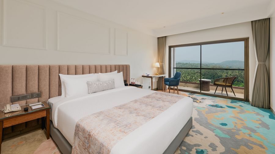 an image of a bedroom with patterned headboard and water bottles placed next to the bed at Cloud9 Sarovar Premiere, Palolem Goa