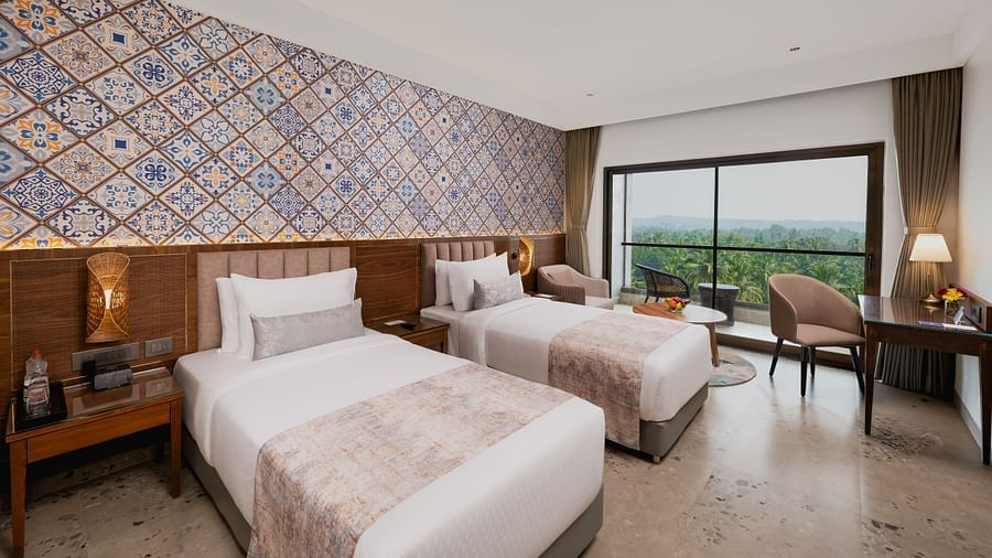 an image of a bedroom with twin beds and a balcony at Cloud9 Sarovar Premiere, Palolem Goa