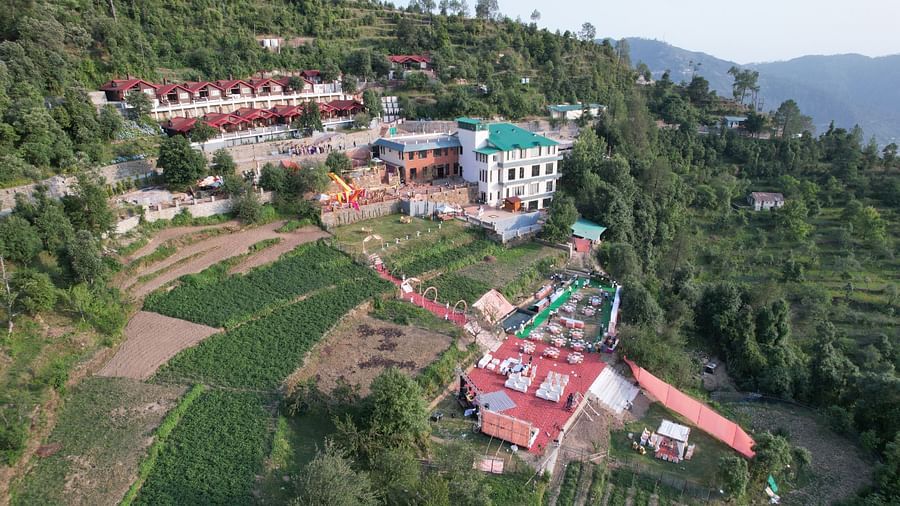 A distant view capturing a building and an outdoor wedding venue nestled amidst mountains.