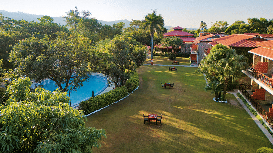 Resort grounds with pool, lush greenery, and well-maintained landscaping.