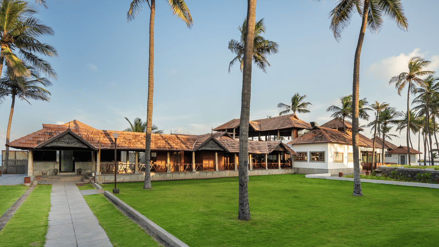 Exterior view of MGM Beach Resorts restaurant complex with open lawns, palm trees, and traditional-style architecture.