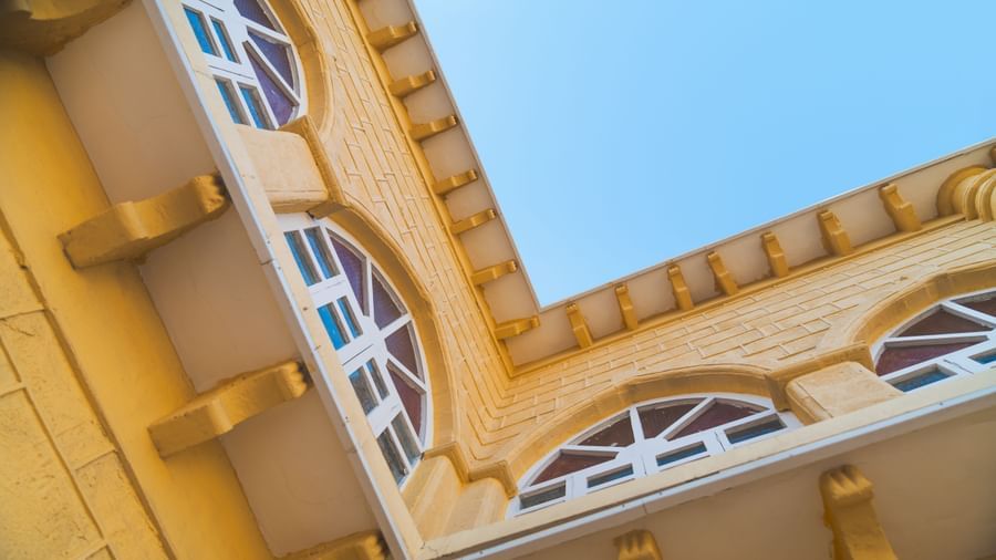 Close up shot of a yellow building with white window panes at The Garden Ananta Elite. 