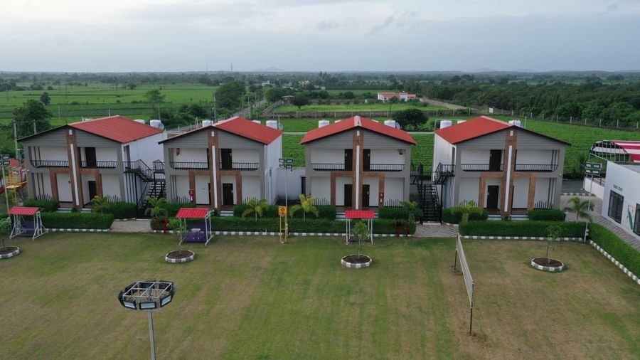 Drone image of VITS Select Diamond Resort, Sasan Gir capturing the front green lawn and red-roofed accommodation blocks.