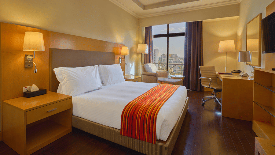 Spacious superior king room featuring a king bed, wooden interiors, and large windows - Ramada by Wyndham Addis
