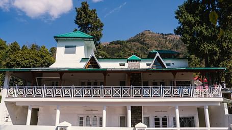 Facade of BluSalzz Villas - The Green Roof, Bhimtal, is set against a stunning backdrop of mountains and lush trees.
