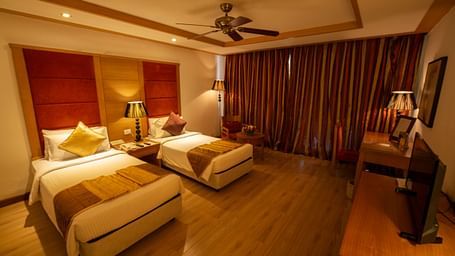 OS-FERNS room with twin beds and a TV at Ocean Spray Puducherry 