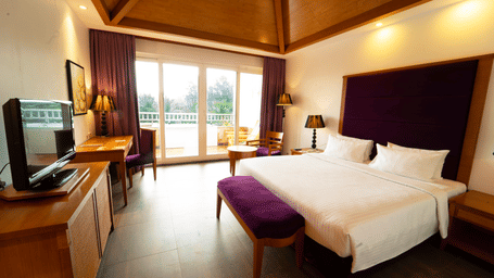 Haven Room at Ocean Spray Resort, Pondicherry featuring a double size bed, a flat TV screen, a work desk and chair, and a balcony attached.