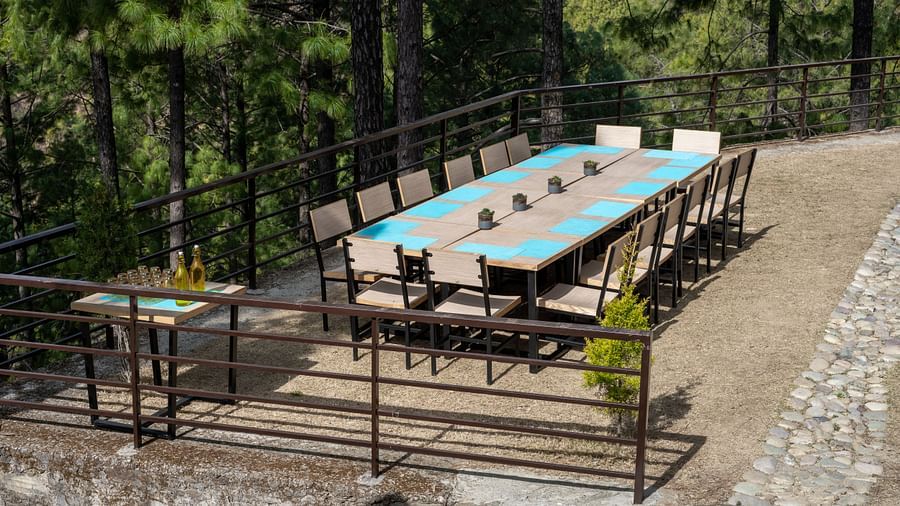 An outdoor lawn featuring a long table surrounded by chairs at BluSalzz Escapade Resort, Lansdowne.