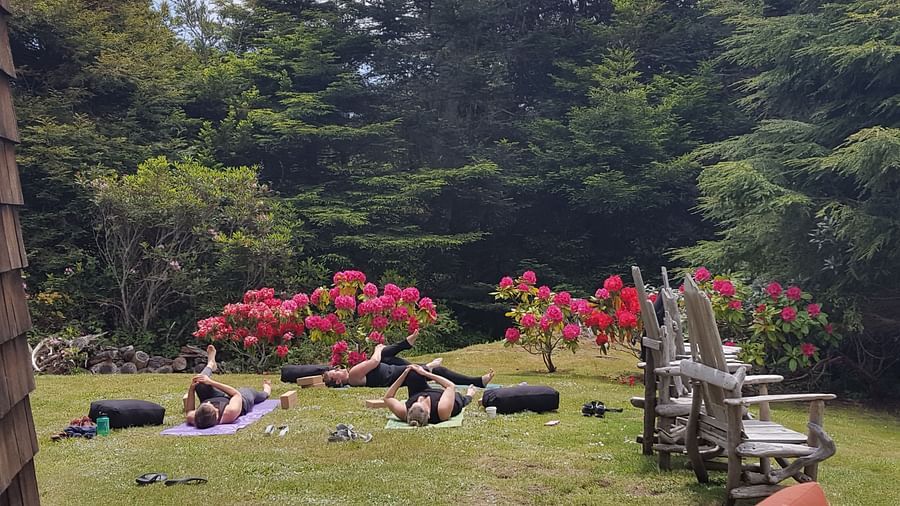 A private yoga session on a well manicured lawn surrounded by lush greenery | Brewery Gulch Inn & Spa