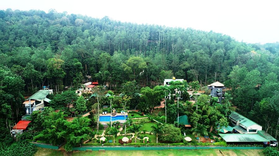 Aerial view of Coorg Jungle Camp Backwater Resort, Kushalnagar surround by lush greenery.