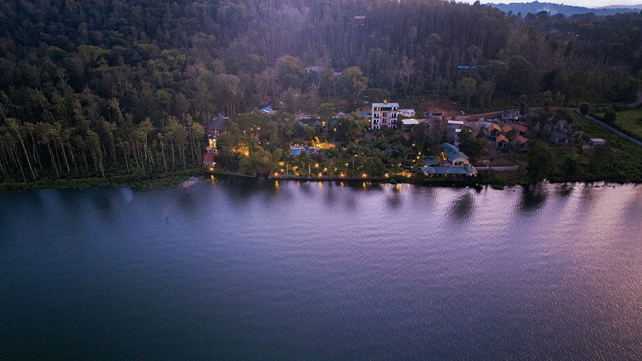 Aerial view of Coorg Jungle Camp with a waterbody in front at Coorg Jungle Camp.