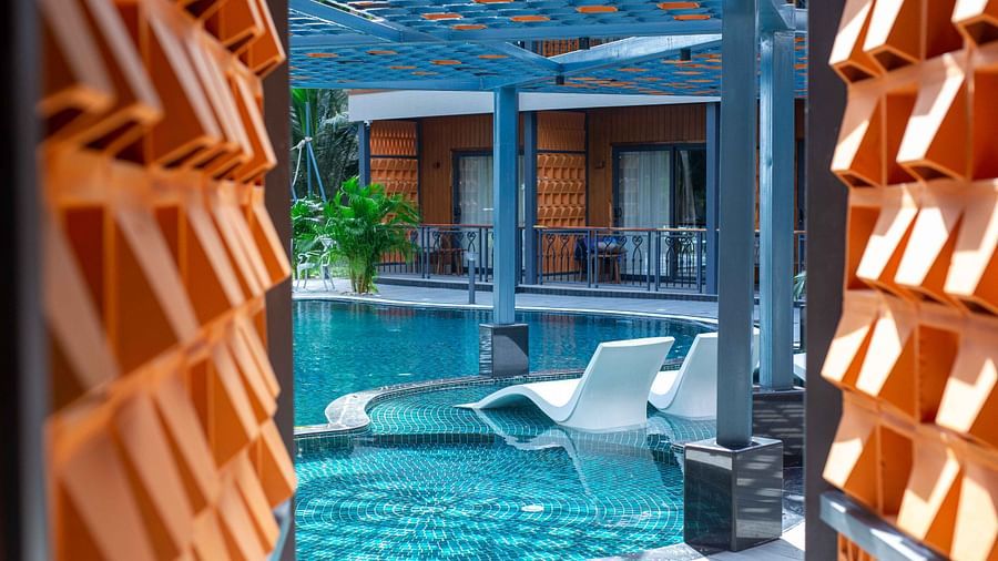  A close-up view of a modern resort pool area with lounge chairs partially submerged in the water. The design offers a serene and luxurious space for guests - Coral Reef Resort & Spa, Havelock