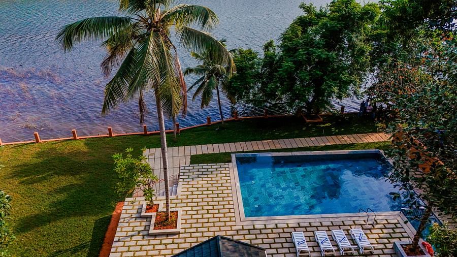 Pool area with lounge chairs and a view of the surrounding landscape.