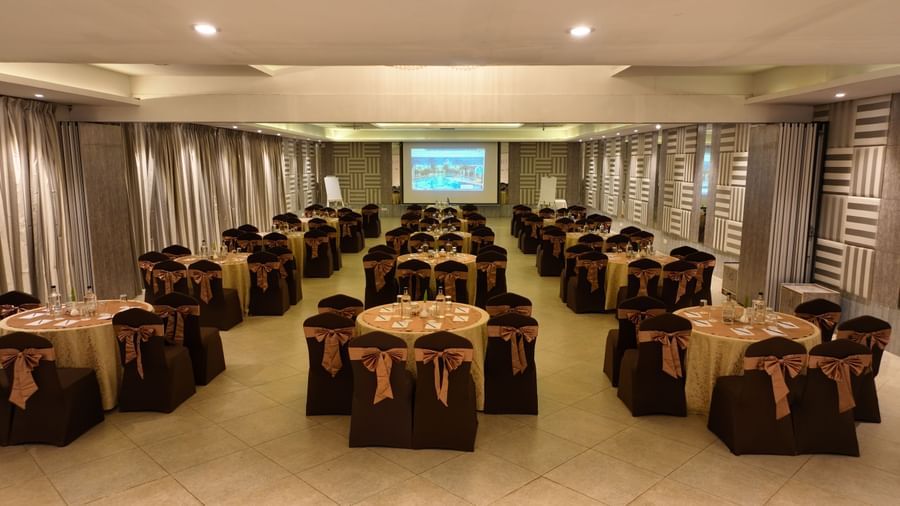 Banquet hall with brown chair covers arranged around round tables at Grande Bay Resort & Spa.