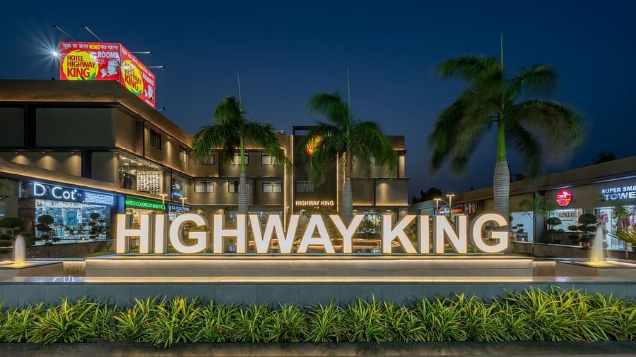 A signage in front of the Hotel Highway King in Behror, with the words 'Highway King' written out on an elevated platform.
