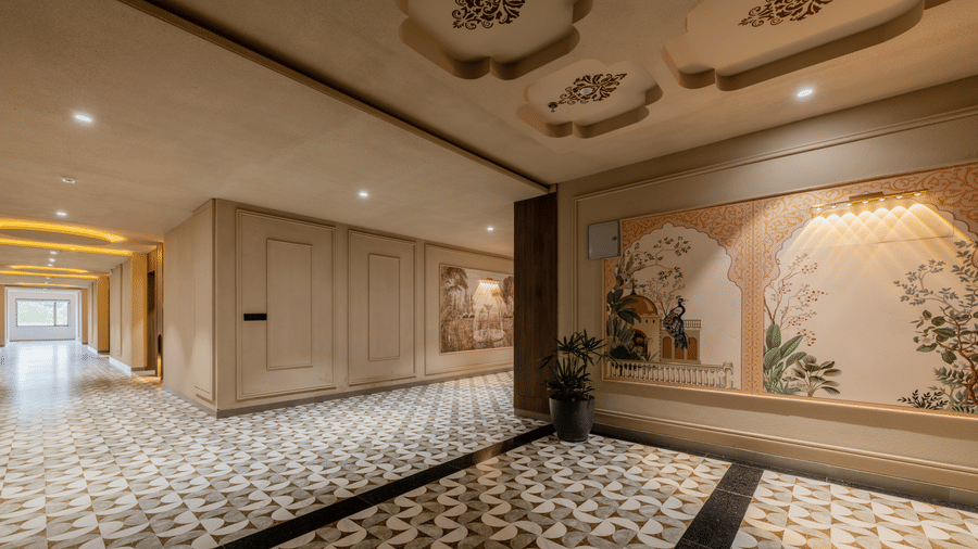 An indoor hallway with geometric patterned floor tiles, decorative wall artwork panels, and warm recessed ceiling lights at Hotel Highway King, Harmada.
