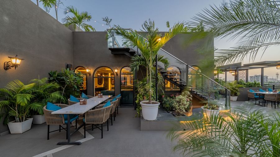 Cosy outdoor dining space surrounded by plants and decorative lighting at Hotel Highway King, Jaipur.