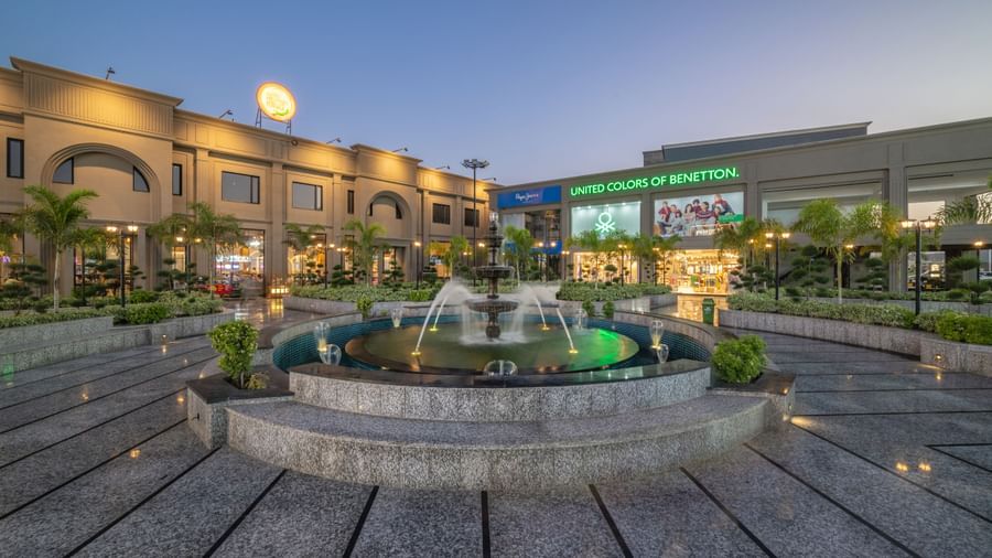 Fountain courtyard with landscaped area and building view at Hotel Highway King, Kishangarh during evening.