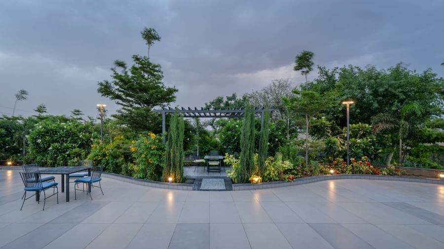A serene landscape showcasing the blue swimming pool and landscaped gardens at Hotel Highway King Shahpura.