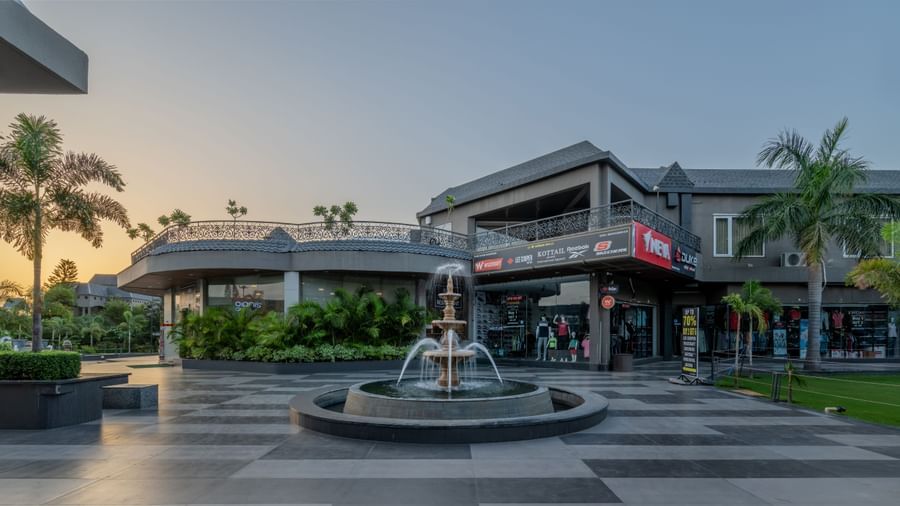 A wide exterior shot of Hotel Highway King Shahpura, featuring a fountain and pathways.
