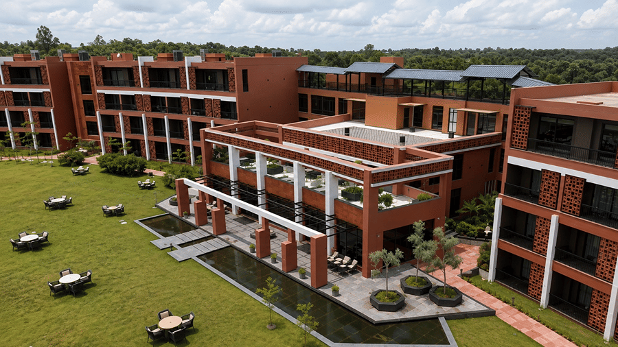An elevated view of Hotel Sonar Bangla, Susunia featuring brick resort buildings, central courtyard, water features, and outdoor lawn seating.