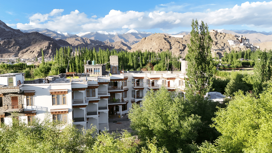 A multi-storeyed building with dense trees in the surroundings. | Indus Serinity, Leh Ladakh