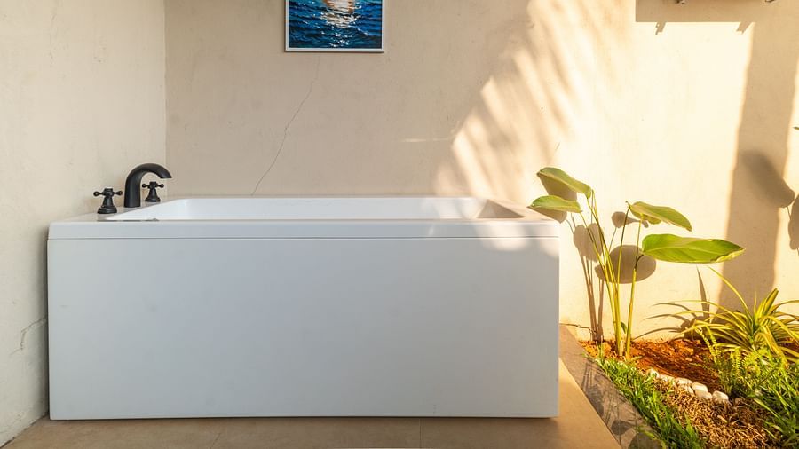 Outdoor bathtub setup surrounded by potted plants and natural sunlight at Kssemya.
