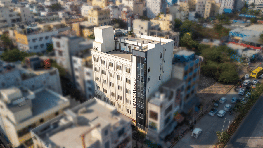 Monday Premium, Madhapur's facade with several other buildings around it.