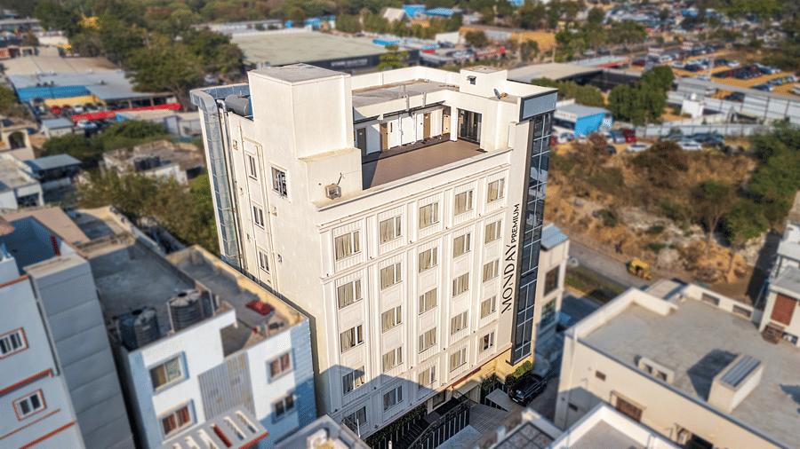 Monday Premium, Madhapur's facade with several other buildings around it.
