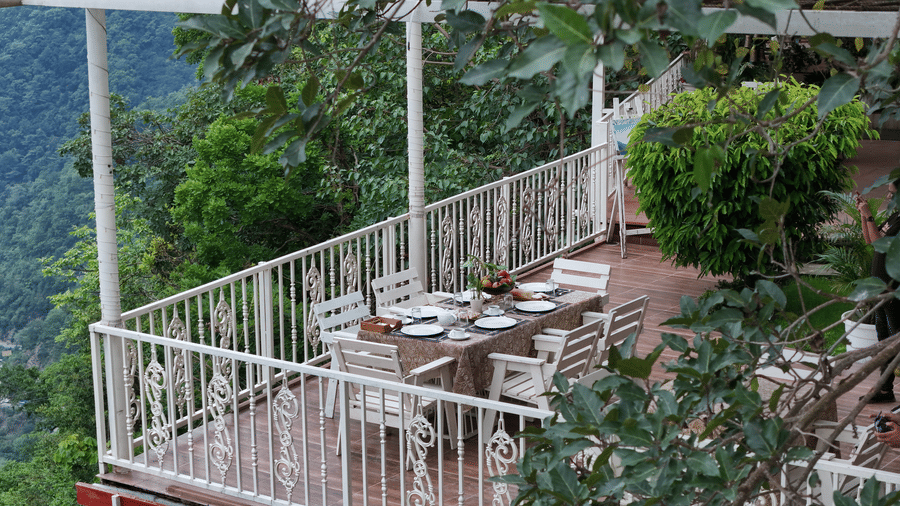 Chairs and table arranged on a rooftop for dining at Neer Ganga.