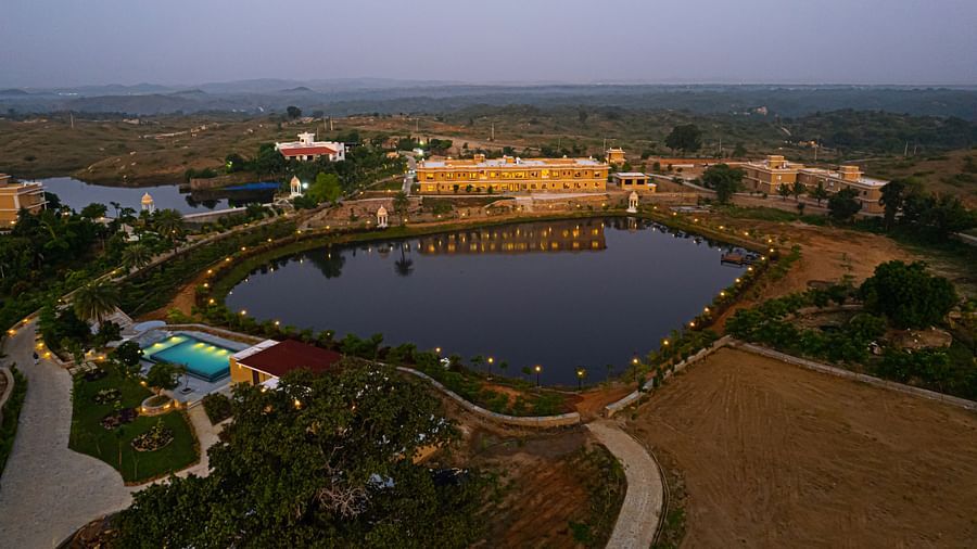 An aerial shot of our property seen during twilight with a water body in front of it - Rajbagh Wellness, Udaipur