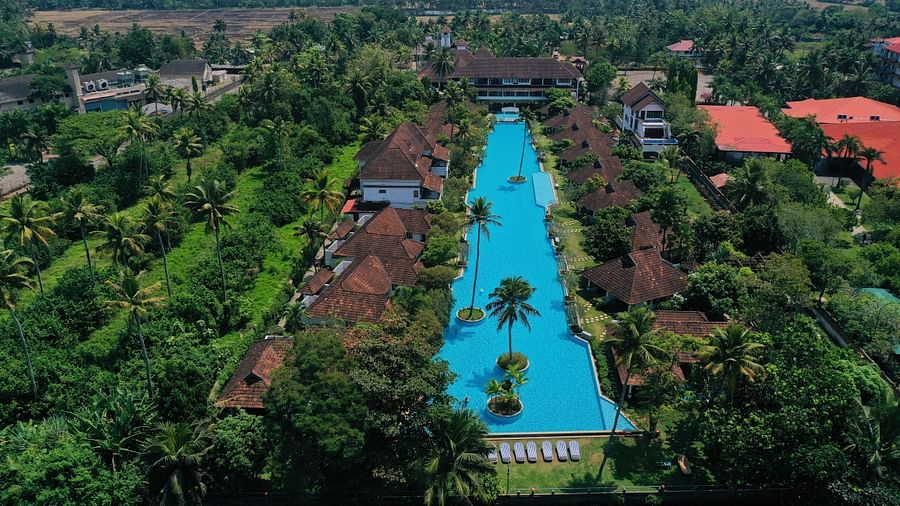 an image of an aerial view of iswimming pool with rooms and trees in view - Rhythm Kumarakom