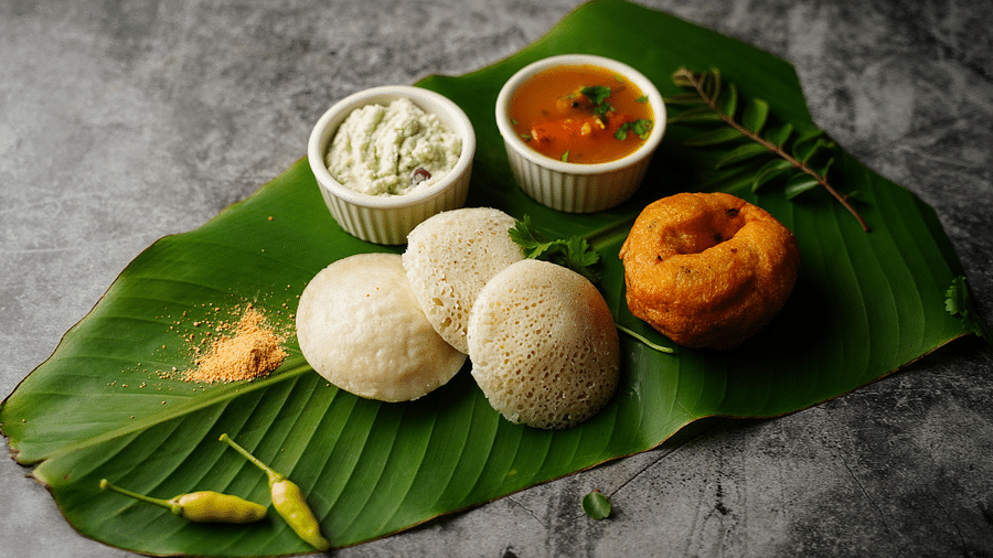 a view from above of Idli and Vada on leaf - Rhythm Kumarakom