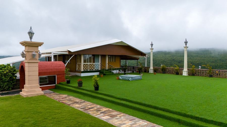 Shot of the facade of the resort clicked from the lush green lawn during a cloudy day | The Grand Legacy Resort and Spa