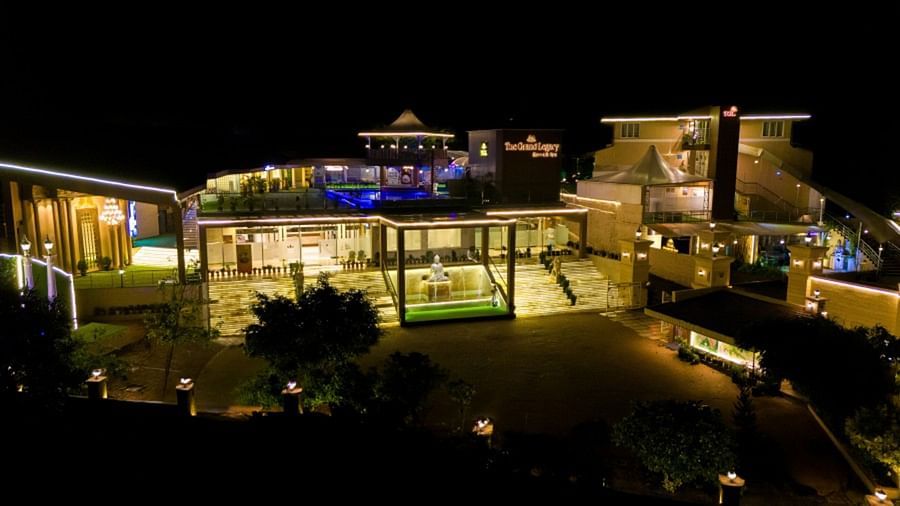  A night view of a resort with illuminated terraces, a swimming pool, and an elegant architectural design.