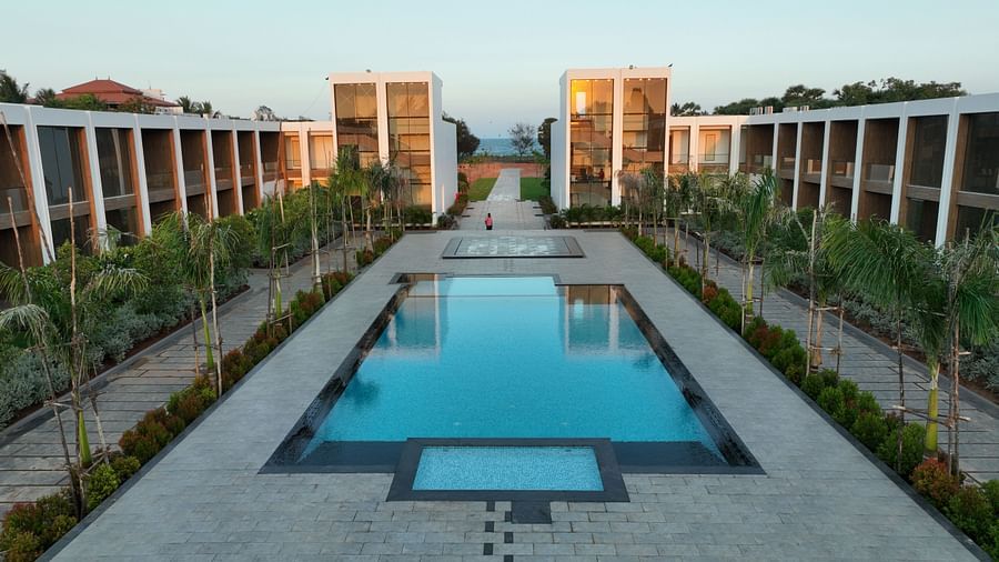 A swimming pool in the middle of The Shore Trishvam, Pondicherry surrounded by a grey pavement.