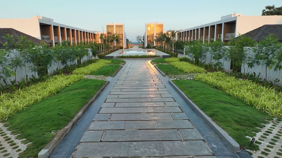 A pathway going to the interiors of the resort during the early evening featuring orange sun rays reflecting off the surface of the pavement at The Shore Trishvam, Pondicherry.