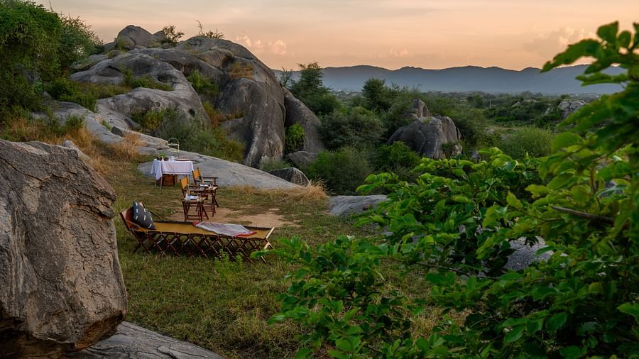 An image of an outdoor seating on top of a hill amidst greenery over viewing the mountains - Utsav Camp Sariska