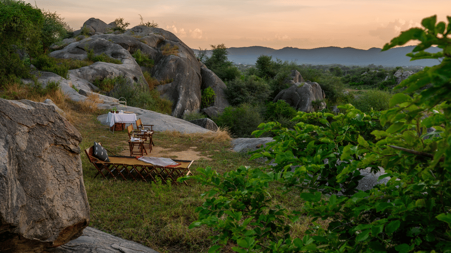 An outdoor seating on top of a hill amidst greenery over viewing the mountains - Utsav Camp Sariska