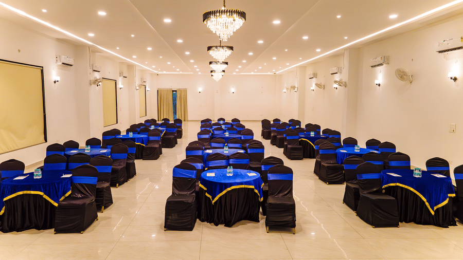 Mystic Jungle Hall at Vedikant Resorts The Mallard Corbett featuring each round tables surrounded by chairs, chandeliers, ceiling lights, fans, air-conditioner, and more.