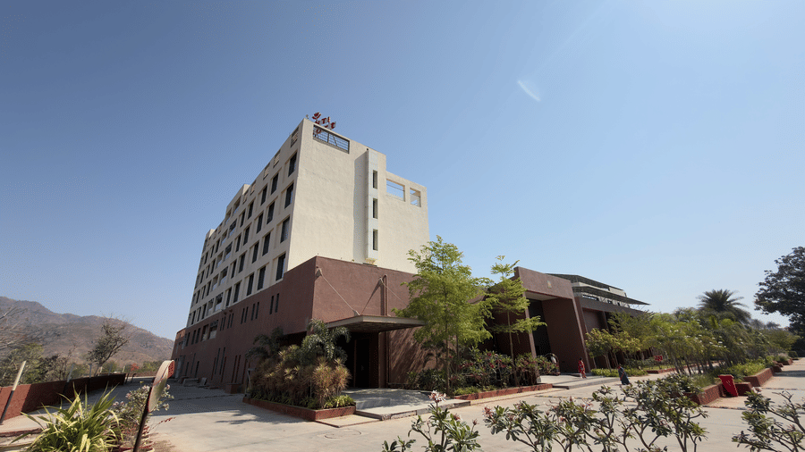 exterior of a Vinti Resort with reddish accents and some palm trees.